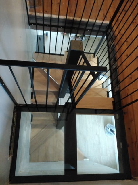 Escalier bois et métal, avec jeu de transparence grâce à des planchers en verre montés sur structure métallique